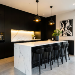 Cuisine moderne noir et blanc avec îlot central, façades mates et plan de travail en marbre.