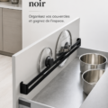 Barre range-couvercles noir moderne installée dans une cuisine organisée, montrant des couvercles bien rangés.